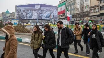Strassenszene in Teheran Ende Februar, im Hintergrund ein Wandbild das zur Parlamentswahl aufruft