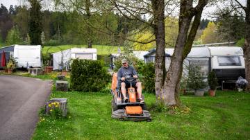 Basil Tulinski mäht mit einem Aufsitz-Rasenmäher den Rasen auf dem Campingplatz