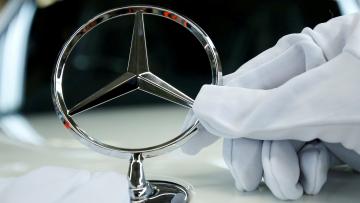 Symbolbild: ein Mercedes-Stern wird auf einem Auto montiert