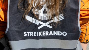 Lieferando-Rider trägt ein Gillet mit dem Aufdruck «Streikerando» an der 1.-Mai-Demo in Hamburg