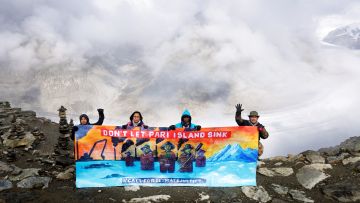 Ibu Asmania und Arif Pujianto halten ein Transparent vor dem Panorama des Aletschgletscher