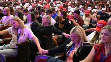 Teilnehmer:innen einer Veranstaltung der Organisation Turning Point USA halten sich an den Hände