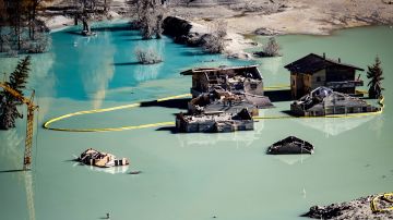 der Schuttkegel des Bergsturzes vom 28. Mai hat die Lonza zu einem See aufgestaut, darin stehen Häuser und ein Baukran im Wasser
