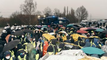Demonstrant:innen vor einem Wasserwerfer in Giessen
