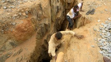 Schürfer klettern aus einem Minenschacht