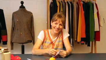 Anne Schlüter sitzt am einem Tisch mit Schneiderei-Utensilien