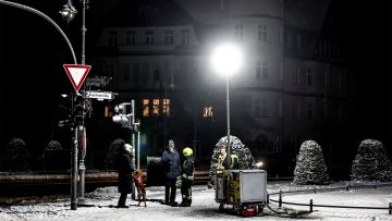 Feuerwehrleute stellen eine mobile Flutlicht-Anlage in Berlin-Zehlendorf auf