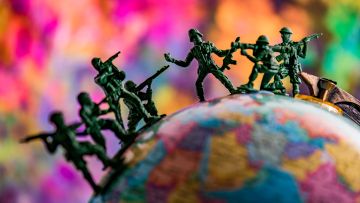 Symbolbild: Spielzeug-Soldaten auf einem Globus