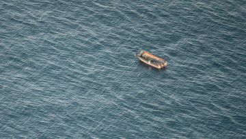 ein verlassenes Boot mit Müllsäcken im Mittelmeer