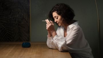 Ece Temelkuran sitzt an einem Tisch und raucht eine Zigarette