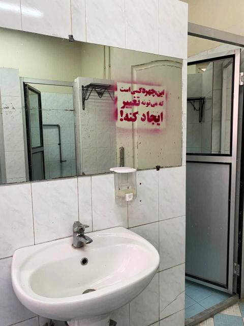 Graffiti auf dem Spiegel eines WCs in der Kunstuniversität von Teheran