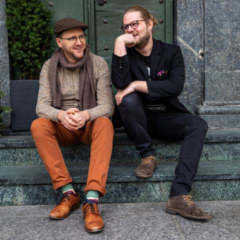 Daniel Blatter und Johannes R. Millius sitzen auf einer Treppe