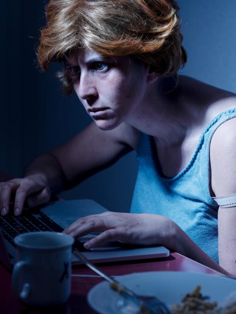 Selbstportrait-Inszenierung von Nora Rupp: Sie schaut mit angestrengtem Blick in den Laptop