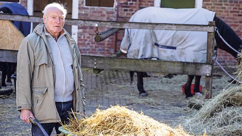 Onno Poppinga schiebt eine Schubkarre voller Stroh