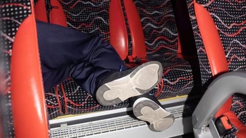 ein:e Bus-Passagier:in schläft auf der Rückbank eines Buses