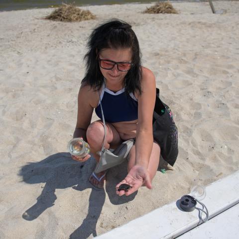Jaroslawa Schubrikowa am Strand von Odesa mit einer kleinen Schildkröte in der Hand