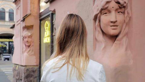 Olga steht verdeckt vor einem Kaffee