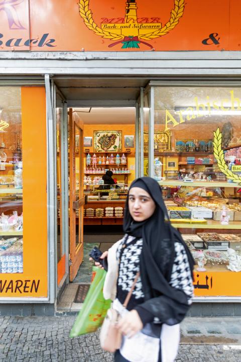 eine Frau vor einem Lebensmittelgeschäft in Neukölln in Berlin