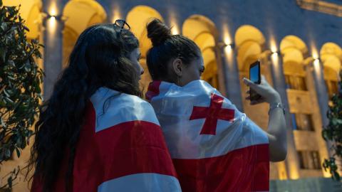 Protest vor dem Parlament in Tbilissi am 30. April: zwei Personen haben die Georgische Flagge umgehängt