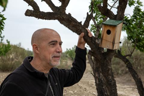 Francisco «Paco» Varela steht neben einem Baum mit Vogelhäuschen