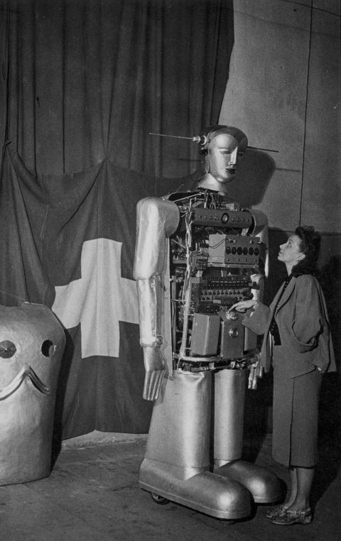 eine Frau steht neben einer Roboter-Attrappe