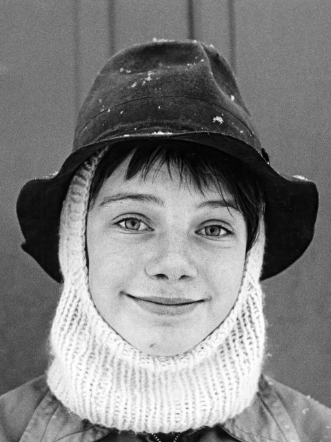 Filmstill aus «Quand nous étions petits enfants»: eine junge Person mit Hut und Schal
