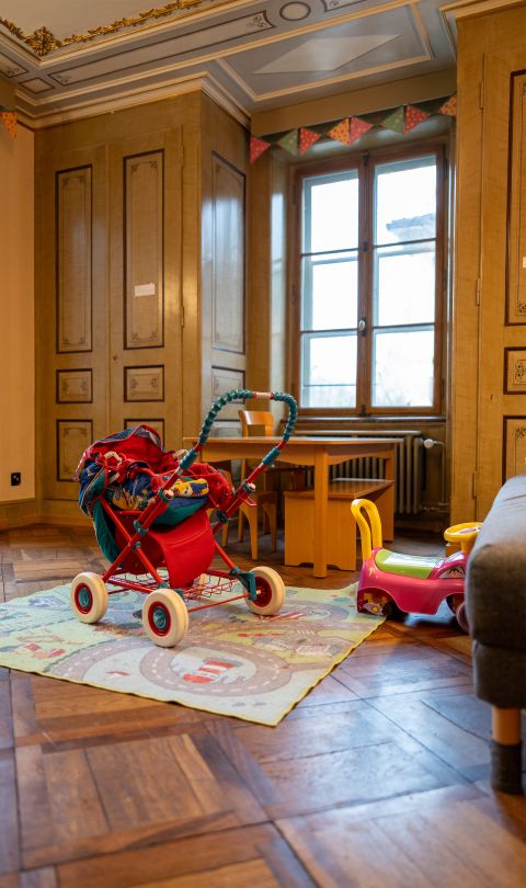 Kinderwagen und Spielzeug in einem Raum des Frauenhaus in Bern
