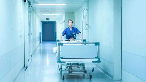 Filmstill aus «Heldin»: eine Krankenpflegerin schiebt ein Spitalbett mit einem Patienten