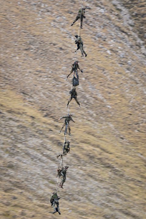 Soldaten hängen an einem Helikopter-Seil bei der Armee-Show auf der Axalp