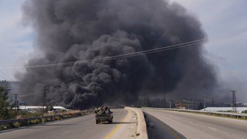 Syrische Regierungstruppen am 7. März auf dem Weg nach Latakia, im Hintergrund sind schwarze Rauchwolken zu sehen