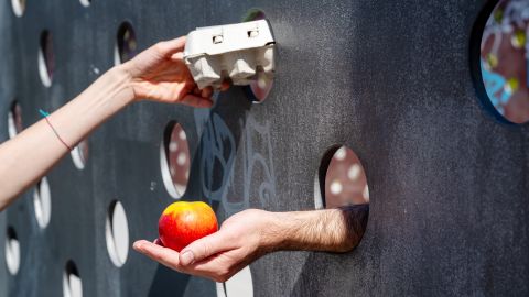 Symbolbild: zwei Hände überreichen einander einen Apfel und eine Packung Eier