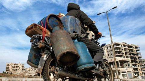 ein Motorrad unterwegs auf der Strasse, schwer beladen mit Gasflaschen und Treibstoffbehältern