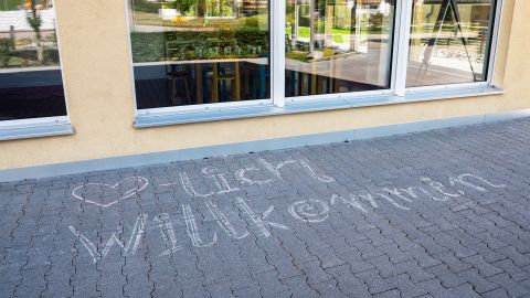 Platz vor der Schule Campus Vivere in Rikon, auf dem «Herzlich Willkommen» mit Kreide geschrieben steht