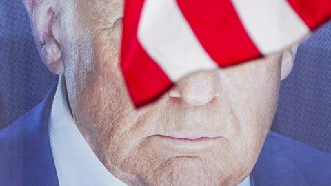 das Gesicht von Trump hinter einer Flagge der USA