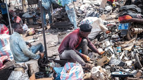 ein Mann sucht in Accra in alten Computern nach Wiederverwertbarem