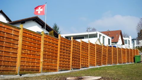 Symbolbild: Holzzaun vor einem Einfamilienhaus