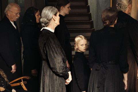Filmstill aus «In die Sonne schauen»: erwachsene Personen mit einem Kind