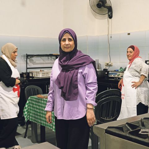 Mariam Al-Shaar steht mit zwei weiteren Frauen in einer Küche