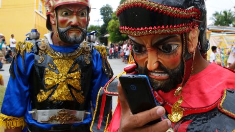 als Römer verkleidete Büsser starren auf ein Smartphone während der Karwoche auf Marinduque, Philippinen