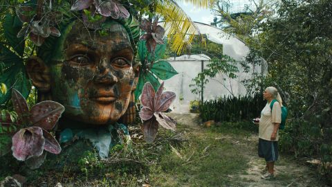 Filmstill aus «Tereza. O último azul»: Denise Weinberg als Alligatorfleischfabrikarbeiterin Tereza steht neben einer Statue