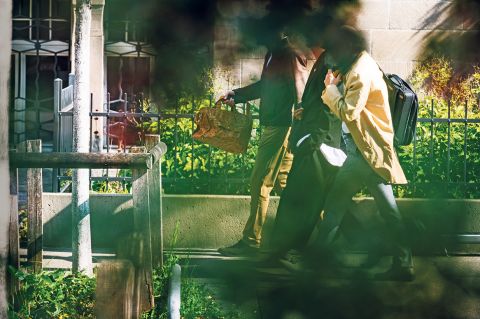 drei Personen laufen auf einem Gehweg