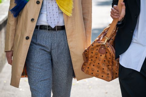 zwei Personen unterwegs in nobler Bekleidung mit einer Luxus-Tasche