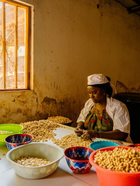 eine Mitarbeiterin sortiert Cashewnüsse