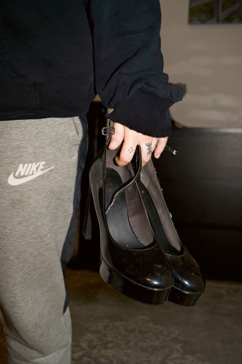 eine Person mit High Heels in der Hand