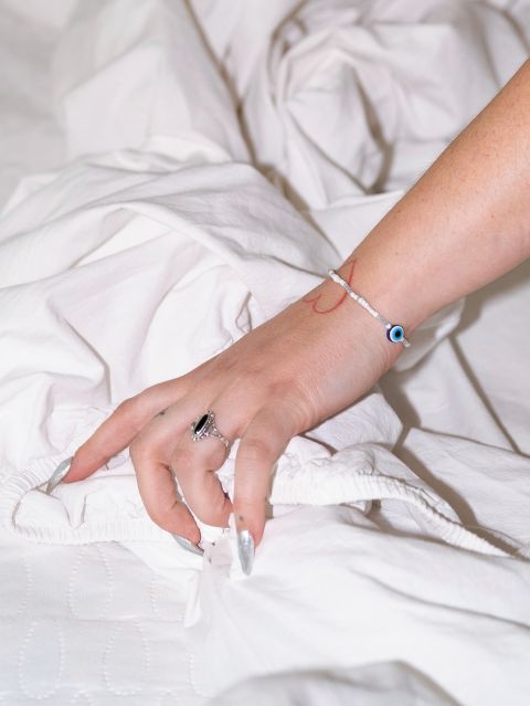 die Hand einer Frau greift in ein Bettlaken