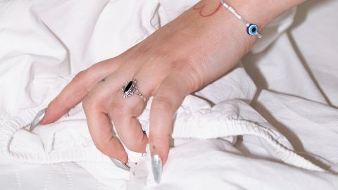 die Hand einer Frau greift in ein Bettlaken