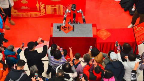 Publikum macht Fotos eines KI-gesteuerten Roboter an einer Wissenschaftsmesse in Beijing