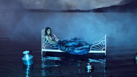 Selbstporträt von Poulomi Basu: sie liegt in einem Bett, welches in einem See steht