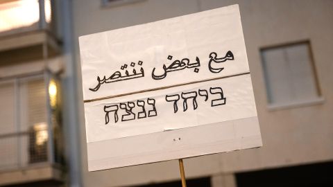 ein Schild auf dem auf Arabisch und Hebräisch «Zusammen werden wir gewinnen» steht