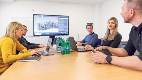 Mitarbeiter:innen der Techfirma Inea bei einer Besprechung